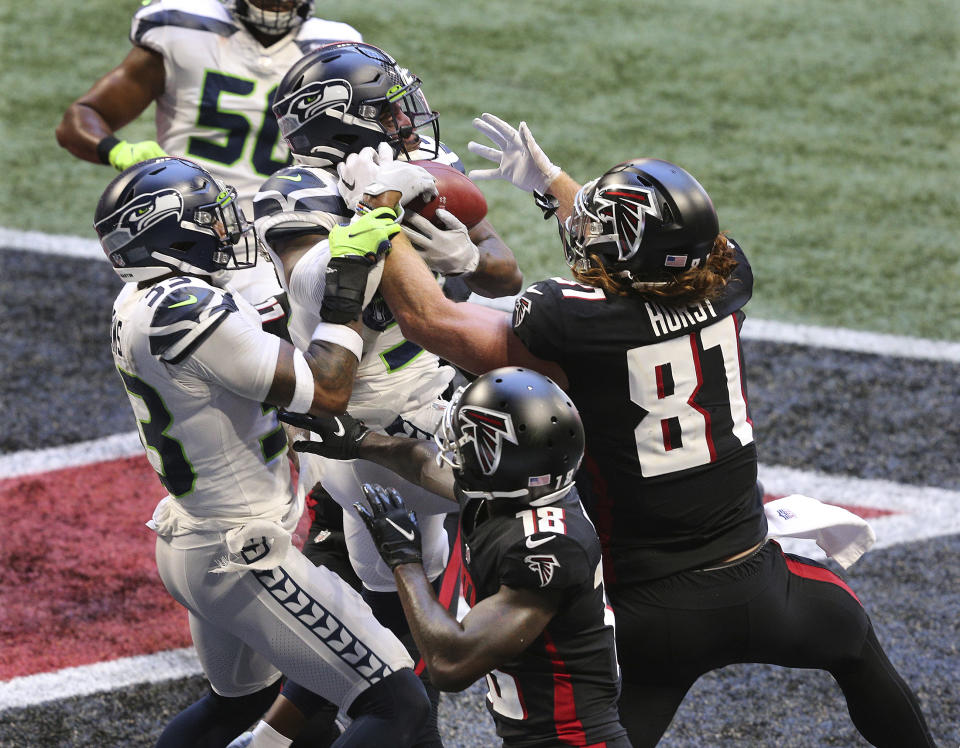 Seattle Seahawks free safety Quandre Diggs, center, goes up for an interception in the end zone on a pass to Atlanta Falcons tight end Hayden Hurst, right, and wide receiver Calvin Ridley (18) during an NFL football game Sunday, Sept. 13, 2020, in Atlanta. (Curtis Compton/Atlanta Journal-Constitution via AP)