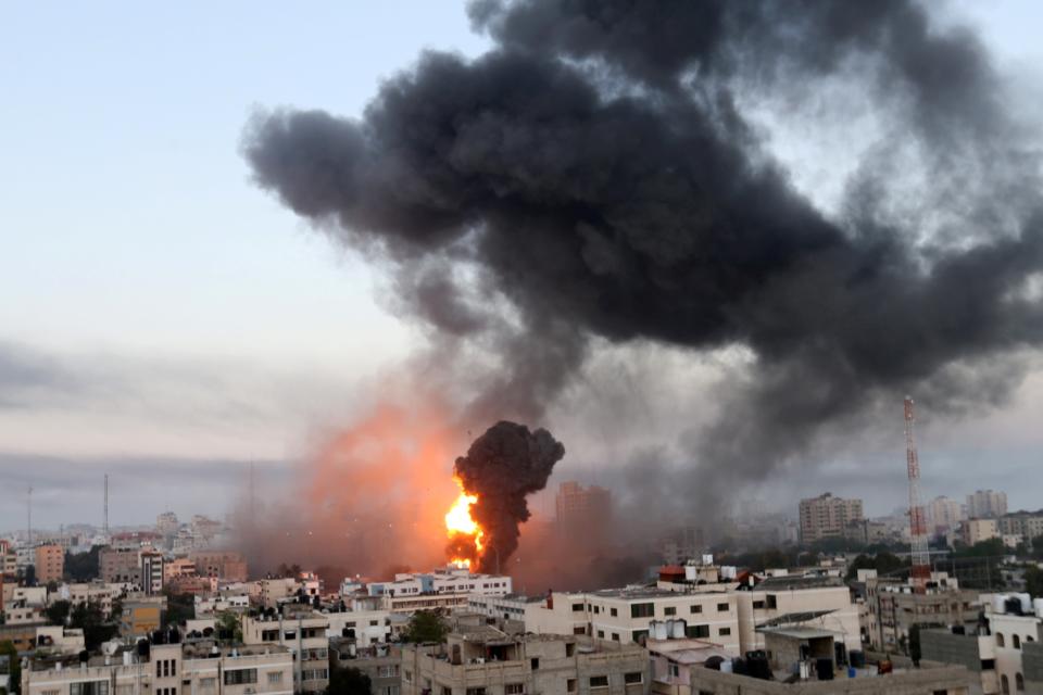 <p>Smoke and flames rise following Israeli airstrikes in Gaza</p> (Reuters)