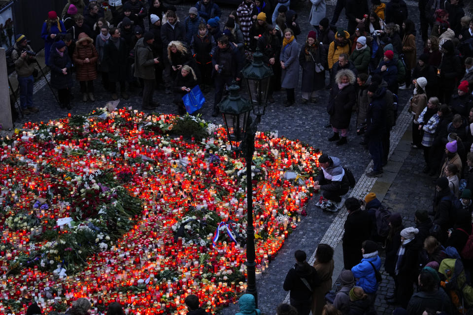 Dolientes llevan flores y velas afuera del edificio de la Facultad de Filosofía de la Universidad Charles en Praga, República Checa, el viernes 22 de diciembre de 2023, un día después de un tiroteo que dejó más de una decena de muertos. (AP Foto/Petr David Josek)