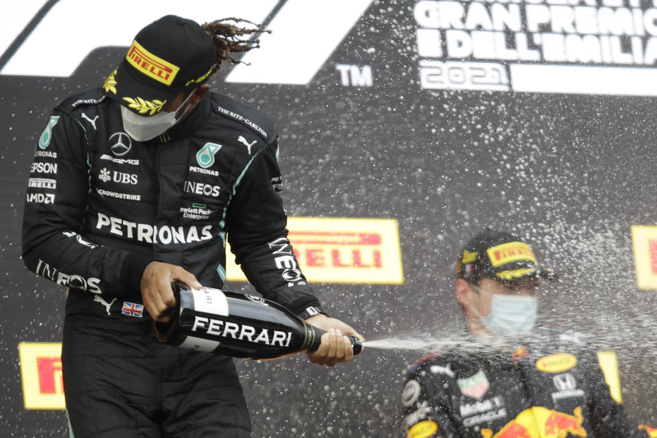 Second placed Mercedes driver Lewis Hamilton of Britain sprays sparkling wine on winner Red Bull driver Max Verstappen of the Netherlands, after the Emilia Romagna Formula One Grand Prix, at the Imola racetrack, Italy, Sunday, April 18, 2021. (AP Photo/Luca Bruno)