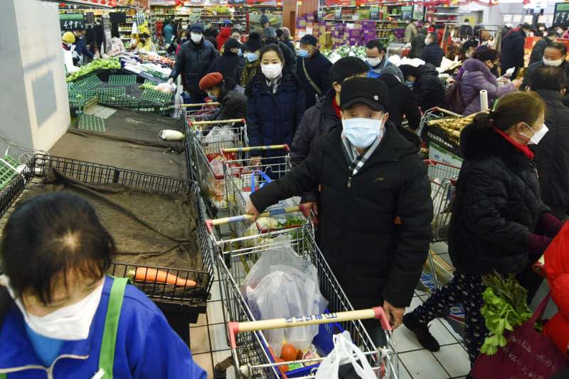 武漢肺炎肆虐，浙江杭州一間超市擠滿了戴著口罩前來搶購生活物品的民眾。（美聯社）