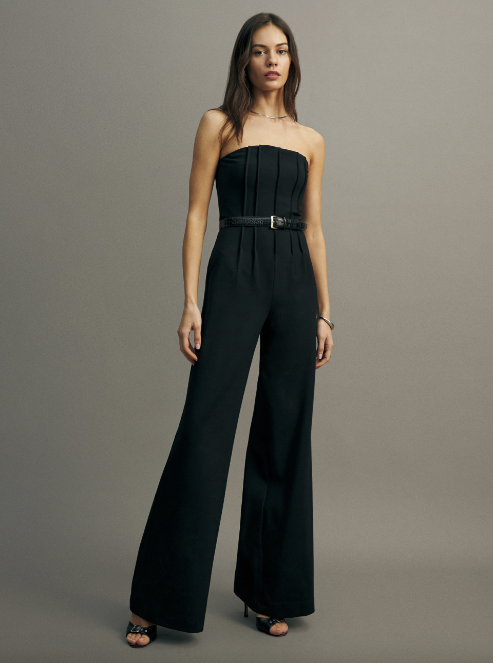 woman wearing black strapless jumpsuit, Ella Knit Jumpsuit (Photo via Reformation)