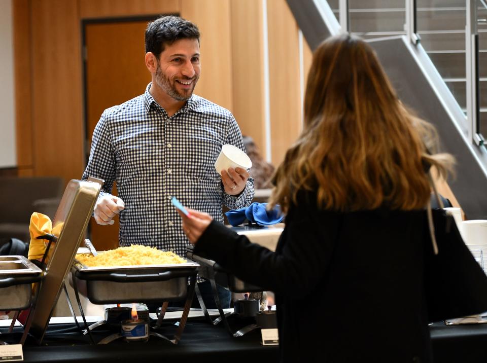 Adam Saltsman, director of Urban Action Institute and assistant professor of urban studies at Worcester State University, dishes out food during a campus fundraiser to collect money for the university's on-campus food pantry, Thea's Pantry.