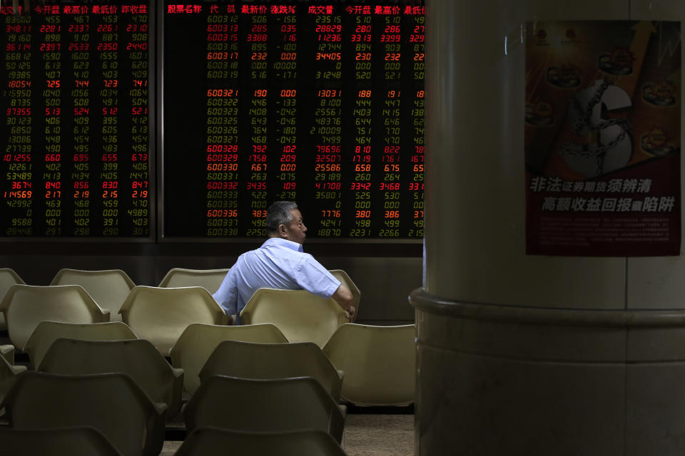 A man sits in front of an electronic board displaying stock prices at a brokerage house in Beijing, Thursday, Aug. 16, 2018. Asian shares are falling as investors fret over slowing economic growth, especially in China. Technology stocks and oil and metals prices skidded overnight on Wall Street.(AP Photo/Andy Wong)