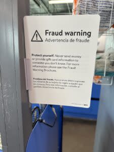 a fraud warning at a gift card display