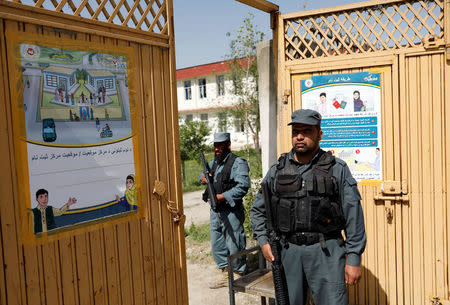 Afghan policemen stand guard at a gate of a voter registration centre for the upcoming parliamentary and district council elections in Kabul, Afghanistan April 23, 2018.REUTERS/Mohammad Ismail