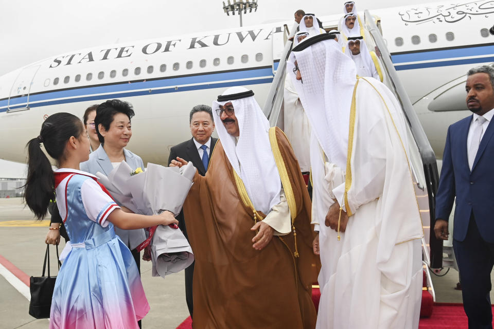 In this photo released by Xinhua News Agency, Kuwait's Crown Prince Sheikh Meshal Al Ahmed Al Jaber Al Sabah receives a bouquet of flowers from a young girl as he arrives in Hangzhou, China, Thursday, Sept. 21, 2023. Kuwaiti crown prince arrived in Hangzhou to attend the opening ceremony of the 19th Asian Games. (Huang Zongzhi/Xinhua via AP)