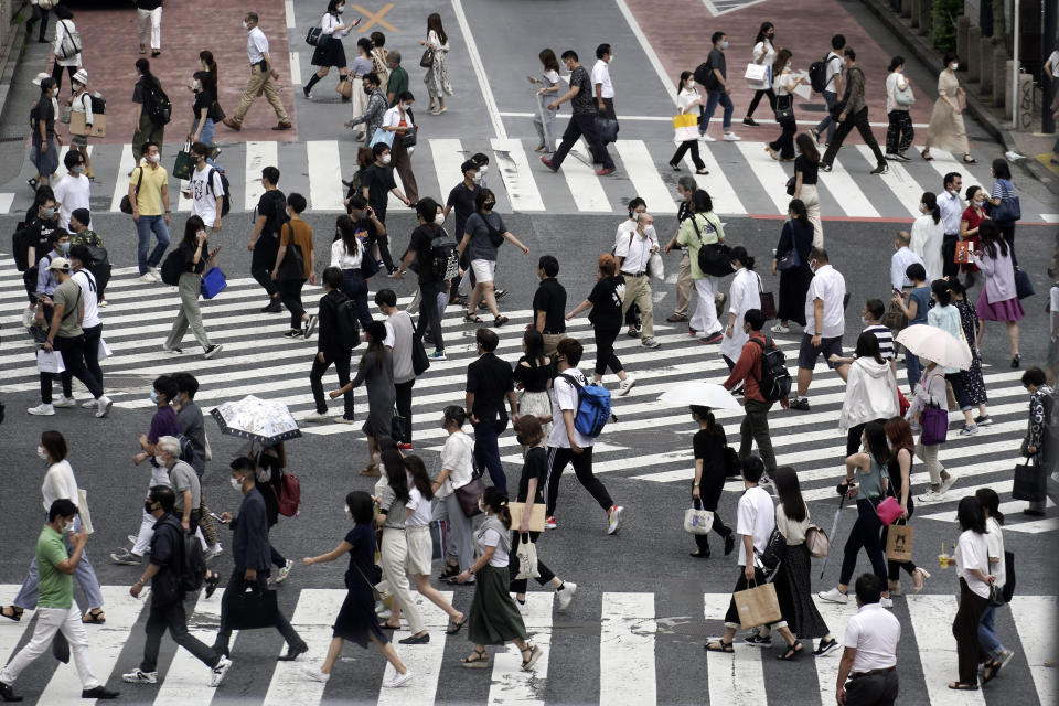 People wearing masks against the spread of the new coronavirus walk at Shibuya pedestrian crossing in Tokyo Friday, July 31, 2020. The Japanese capital confirmed Friday more than 400 new coronavirus cases. / Credit: Eugene Hoshiko / AP