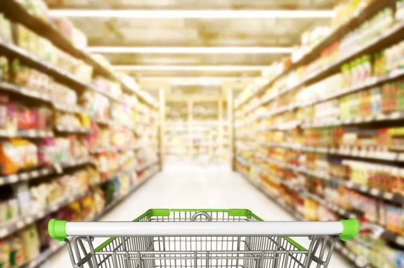 A shopping cart in a supermarket aisle.