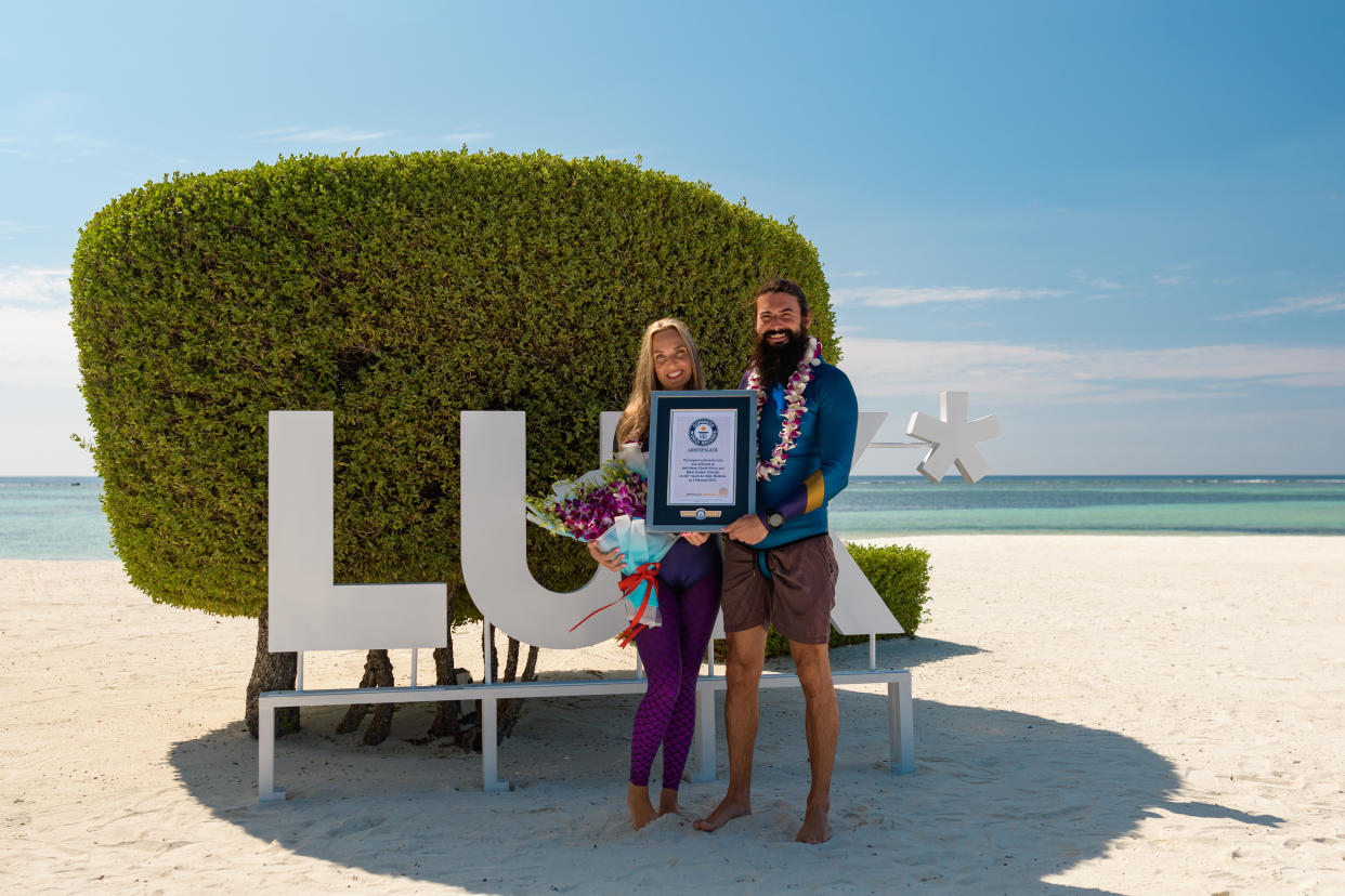 Couple standing together and holding a certificate