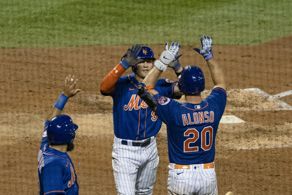 New York Mets' Luis Guillorme, left, celebrates with teammates Brandon Nimmo (9) and Pete Alonso (20) after a two-run double by Michael Conforto during the sixth inning of a baseball game Wednesday, Aug. 12, 2020, in New York. (AP Photo/Frank Franklin II)