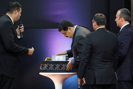 Venezuela's President Nicolas Maduro (C) examines a cryptocurrency mining computer during the event launching the new Venezuelan cryptocurrency "Petro" in Caracas, Venezuela February 20, 2018. REUTERS/Marco Bello