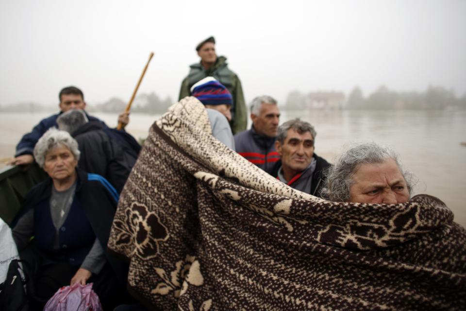 People sit in a boat after being evacuated by Serbian army soldiers from their houses in the town of Obrenovac, east from Belgrade May 16, 2014. (REUTERS/Marko Djurica)