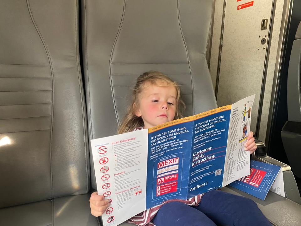 lauren's daughter reading a train brochure on an amtrak train