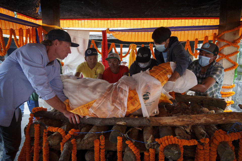 Partner Jim Morrison, left, performs rituals during the funeral of famed American extreme skier Hilaree Nelson in Kathmandu, Nepal, Sunday, Oct.2, 2022. Nelson had died last week on Mount Manaslu while coming down from the top of the summit the 8,163-meter (26,775-foot) world's eighth-highest mountain. (AP Photo/Niranjan Shrestha)