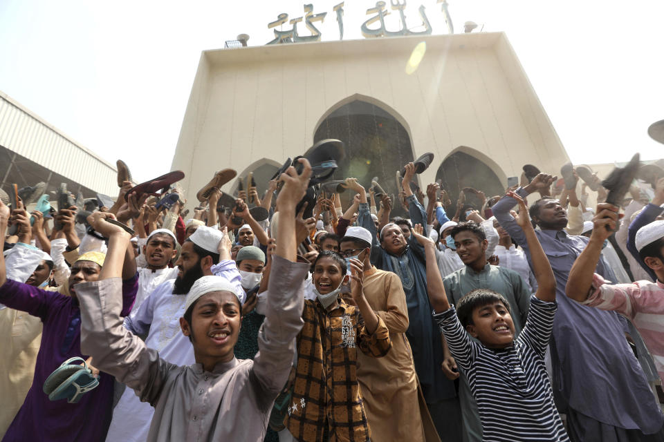 A group of protestors shout slogans and wave shoes after Friday prayers at Baitul Mokarram mosque in Dhaka, Bangladesh, Friday, March 26, 2021. Witnesses said violent clashes broke out after one faction of protesters began waving their shoes as a sign of disrespect to Indian Prime Minister Narendra Modi, and another group tried to stop them. Local media said the protesters who tried to stop the shoe-waving are aligned with the ruling Awami League party. The party criticized the other protest faction for attempting to create chaos in the country during Modi’s visit. (AP Photo/Mahmud Hossain Opu)