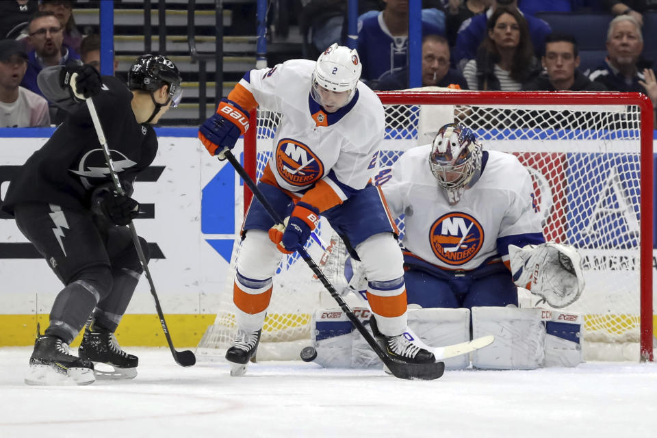 New York Islanders goaltender Semyon Varlamov, of Russia, makes a save as Nick Leddy defends against Yanni Gourde during the first period of an NHL hockey game Saturday, Feb. 8, 2020, in Tampa, Fla. (AP Photo/Mike Carlson)