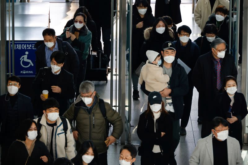 FILE PHOTO: People wearing masks walk at a railway station amid the coronavirus disease (COVID-19) pandemic in Seoul