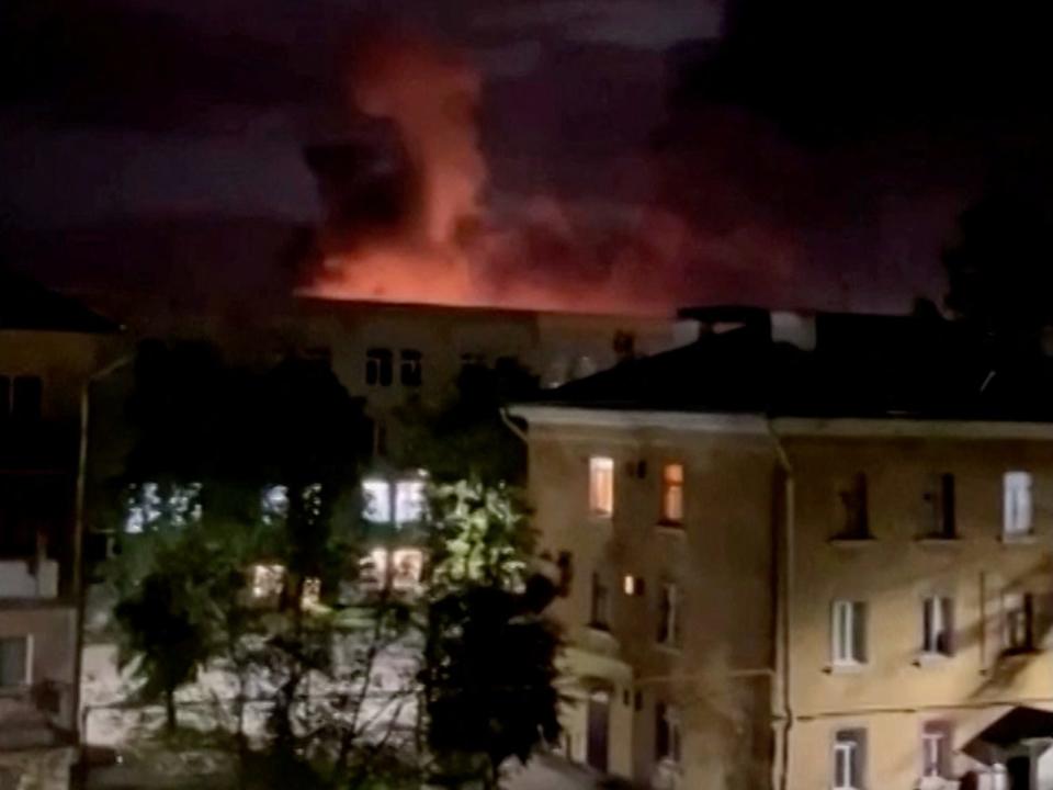 A plume of smoke is illuminated by a flash of light amid a drone attack in Pskov, Russia, in this still image obtained from social media video released August 30, 2023.