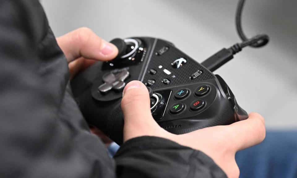 A visitor play a video game with an Microsoft Xbox controller