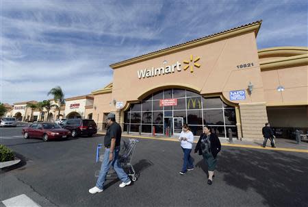 Customers walk outside a Wal-Mart store in the Porter Ranch section of Los Angeles, California in this November 26, 2013 file photo. REUTERS/Kevork Djansezian/Files