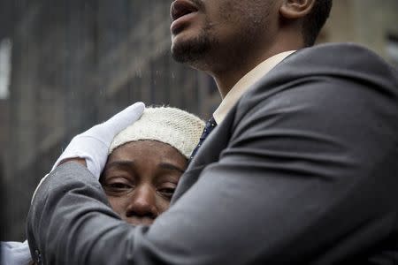 Family members embrace following the funeral for Akai Gurley at the Brown Memorial Baptist Church in Brooklyn, New York December 6, 2014. REUTERS/Brendan McDermid