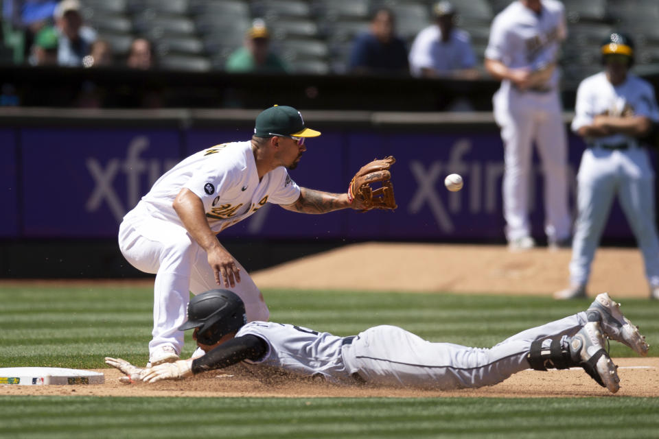 Chicago White Sox's Zach Remillard, bottom, slides safely into third base with a triple as Oakland Athletics third baseman Jace Peterson, top, takes a relay during the sixth inning of a baseball game, Sunday, July 2, 2023, in Oakland, Calif. (AP Photo/D. Ross Cameron)