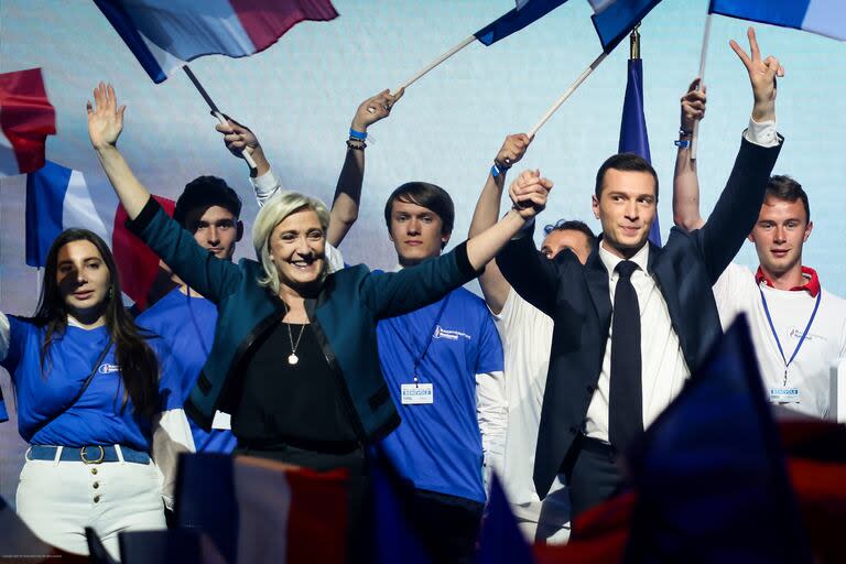 La líder del partido francés de ultraderecha Agrupación Nacional, Marine Le Pen, a la izquierda, y el candidato principal del partido para las próximas elecciones europeas, Jordan Bardella asisten a un acto político el domingo 2 de junio de 2024 en París. (AP Foto/Thomas Padilla)