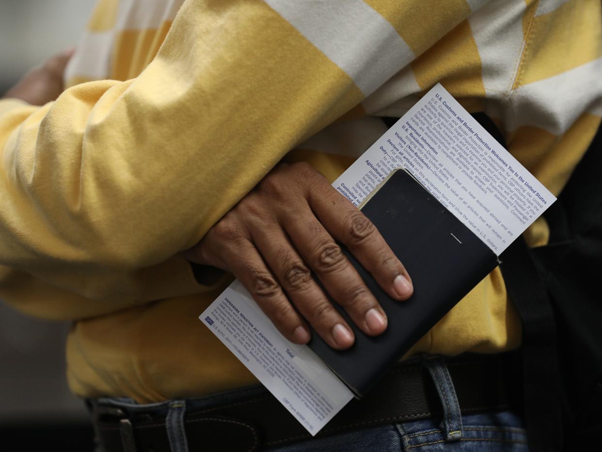 A traveler carries his passport and declaration as he goes through U.S. Customs and Border Protection.