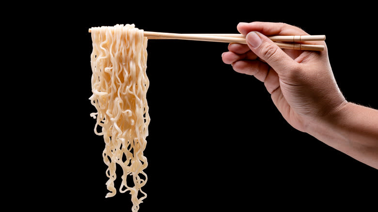 chopsticks holding ramen noodles