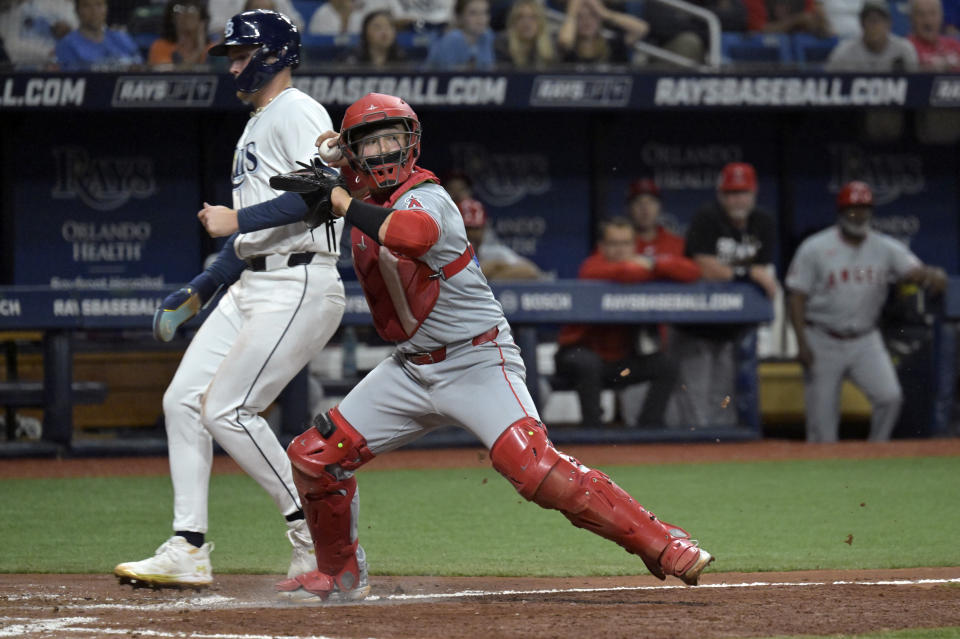 Los Angeles Angels catcher Matt Thaiss, right, forces out Tampa Bay Rays' Curtis Mead at the plate on a bases-loaded ground ball hit by Tampa Bay's Yandy Diaz during the fifth inning of a baseball game Monday, April 15, 2024, in St. Petersburg, Fla. (AP Photo/Steve Nesius)