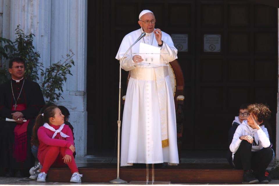 Pope Francis speaks to the faithful gathered outside the Basilica of Our Lady of Loreto where, during a one-day visit, he celebrated mass and prayed in the shrine containing a small house traditionally venerated as the house of Mary, and believed miraculously transplanted from the Holy Land inside the Basilica, in central Italy, Monday, Mar. 25, 2019. The pope chose Loreto to sign the Post-Synodal Exhortation of last October's Synod of Bishops. (AP Photo/Domenico Stinellis)