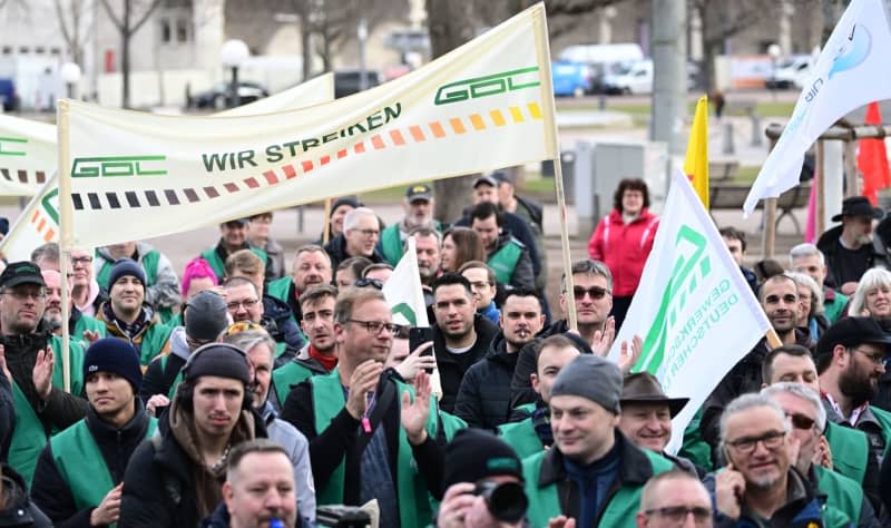 Supporters of the German Train Drivers' Union (Gewerkschaft Deutscher Lokomotivführer) hold a banner reading "We are on strike" at a GDL rally on Schlossplatz. The train drivers' union GDL has called on Deutsche Bahn employees to strike. Bernd Weißbrod/dpa