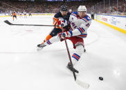 New York Rangers' Kaapo Kakko (24) and Edmonton Oilers' Cody Ceci (5) compete for the puck during the third period of an NHL hockey game Friday, Nov. 5, 2021, in Edmonton, Alberta. (Jason Franson/The Canadian Press via AP)