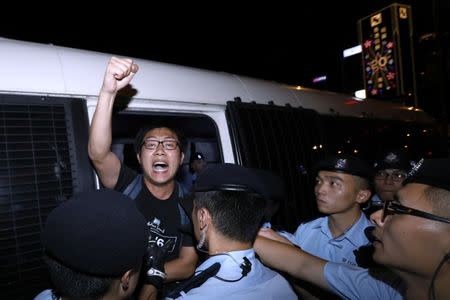 Pro-democracy activist Raphael Wong shouts as he is carried by policemen as protesters are arrested at a monument symbolising the city's handover from British to Chinese rule, a day before Chinese President Xi Jinping is due to arrive for the celebrations, in Hong Kong, China June 28, 2017. REUTERS/Tyrone Siu