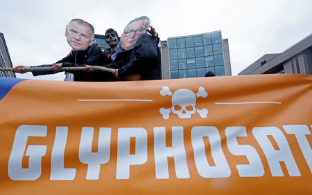 Protestors wearing make-up and masks depicting a skull, EU Commissioner for Health and Food Safety Vytenis Andriukaitis (L) and European Commission President Jean-Claude Juncker demonstrate against a five-year extension of the license for weed-killer glyphosate that the European Commission will propose on Monday, in Brussels, Belgium, November 27, 2017. REUTERS/Yves Herman