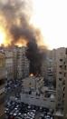 Fire and smoke is seen at the site of an explosion in Beirut's southern suburbs January 2, 2014. The powerful explosion struck southern Beirut on Thursday, a stronghold of the Shi'ite group Hezbollah, killing at least two people and sending a column of smoke into the sky, a witness said. (REUTERS/Jamal Sahili)