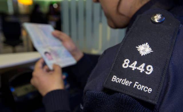 A Border Force officer checking passports