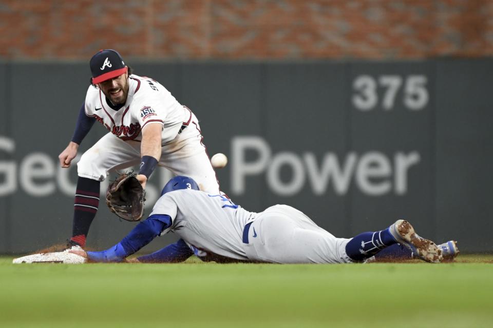 Dodgers' Chris Taylor, right, steals second base ahead of the catch by Braves shortstop Dansby Swanson
