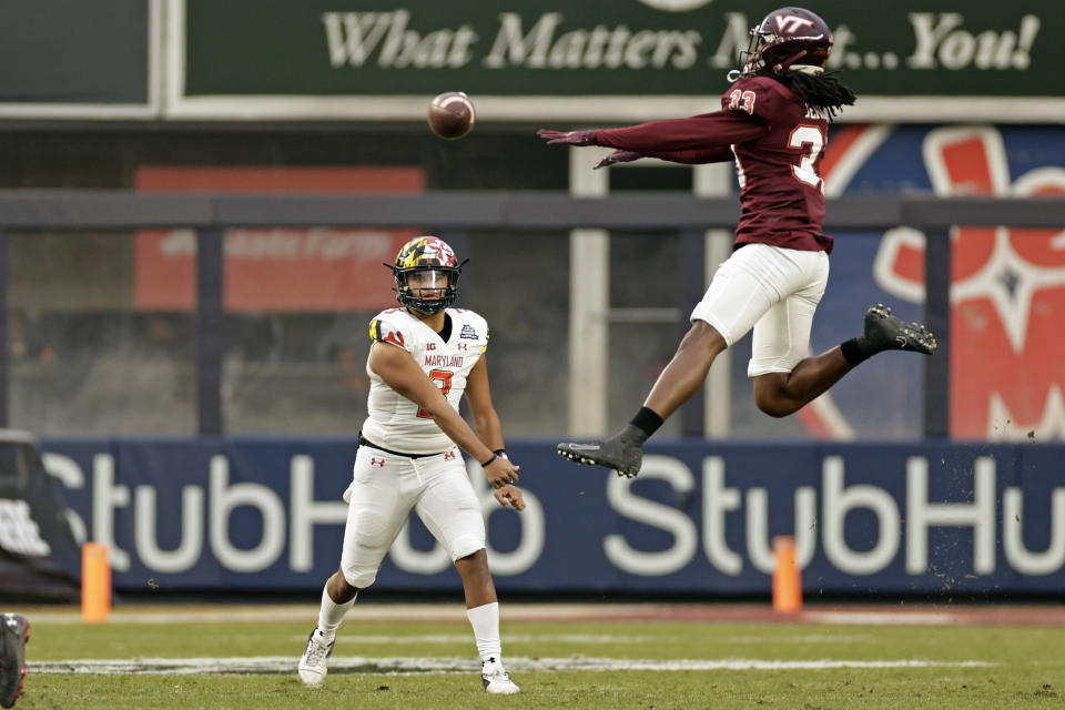 Maryland quarterback Taulia Tagovailoa (3) passes under pressure from Virginia Tech defensive back Keonta Jenkins (33) during the first half of the Pinstripe Bowl NCAA college football game in New York, Wednesday, Dec. 29, 2021. (AP Photo/Adam Hunger)