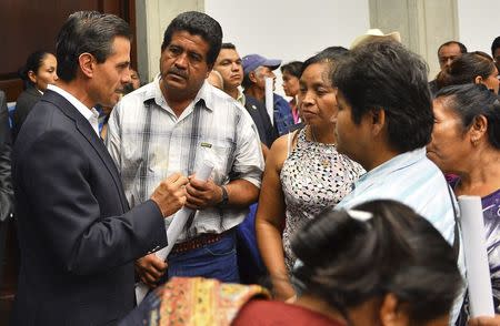 Mexico's President Enrique Pena Nieto (L) talks to relatives of the 43 missing students of Ayotzinapa Teacher Training College at the Los Pinos presidential residence in Mexico City in this October 29, 2014 handout picture provided by the Presidency of Mexico. REUTERS/Mexico Presidency/Handout via Reuters