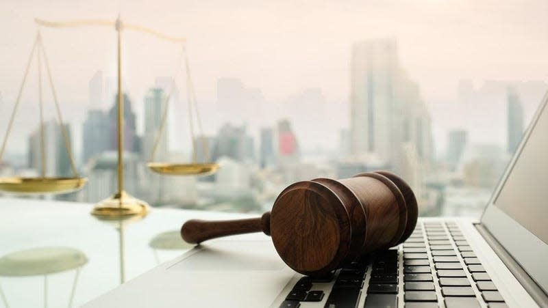 A gavel and the scales of justice pictured with a laptop. 