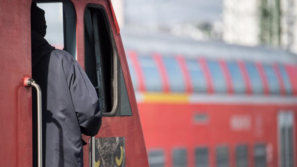 Ein Lokführer steht im Hauptbahnhof von Stuttgart an der Tür zu einem Führerstand. Foto: Sebastian Gollnow/Illustration