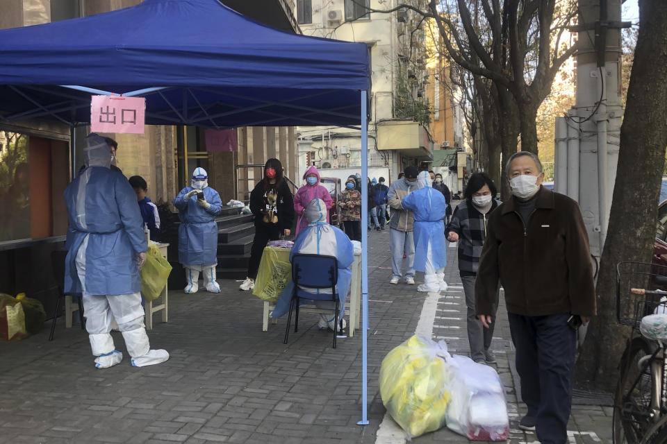 Medical workers conduct mass testing for residents in a lockdown area in the Jingan district of western Shanghai, Monday, April 4, 2022. China has sent more than 10,000 health workers from across the country to Shanghai, including 2,000 military medical staff, as it struggles to stamp out a rapidly spreading COVID-19 outbreak in China's largest city. (AP Photo/Chen Si)