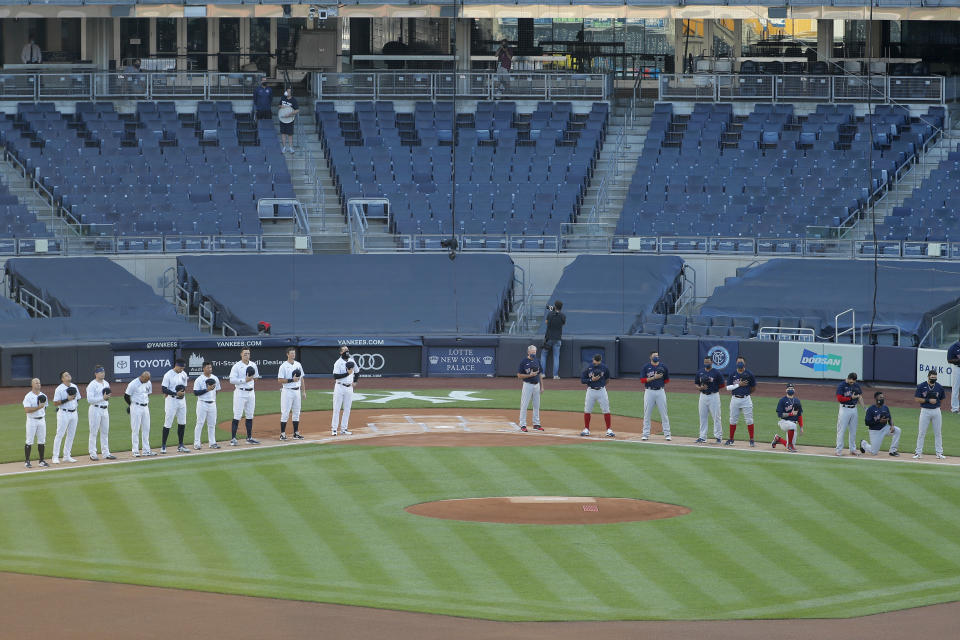 The New York Yankees, left, and the Boston Red Sox line up for the national anthem before the baseball game at Yankee Stadium, Friday, July 31, 2020, in New York. (AP Photo/Seth Wenig)