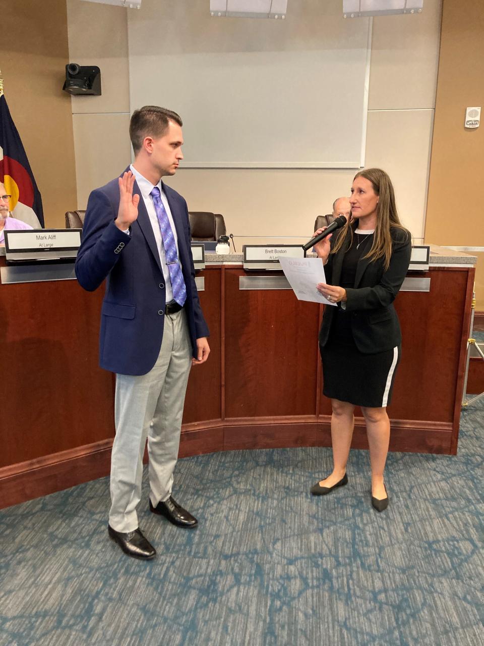 City Clerk Marisa Stoller (right) administers the oath of office to the newest at-large city councilor, Brett Boston, on June 24, 2024.