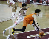 Oklahoma State guard Cade Cunningham (2) goes against Oklahoma guard Elijah Harkless (24) during the second half of an NCAA college basketball game, Saturday, Feb. 27, 2021, in Norman, Okla. (AP Photo/Garett Fisbeck)