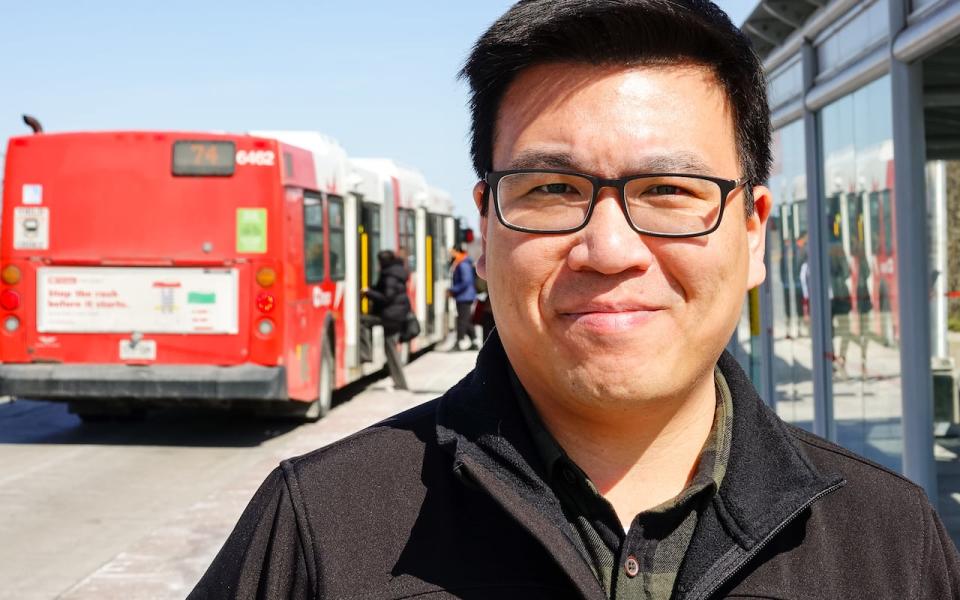 Barrhaven East Coun. Wilson Lo at an OC Transpo bus stop on March 25, 2024.