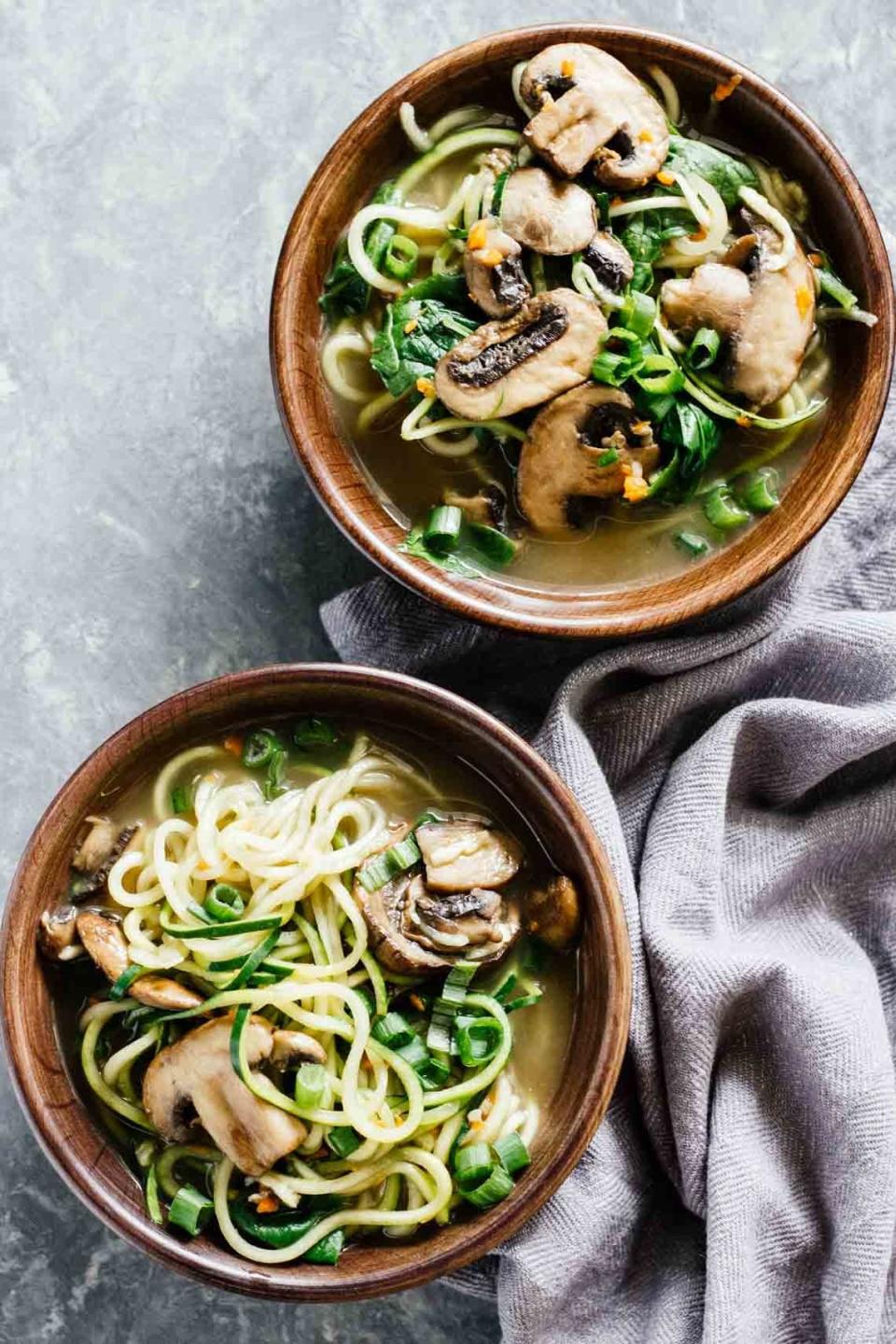 Zucchini noodles, mushrooms, and broth in two brown bowls