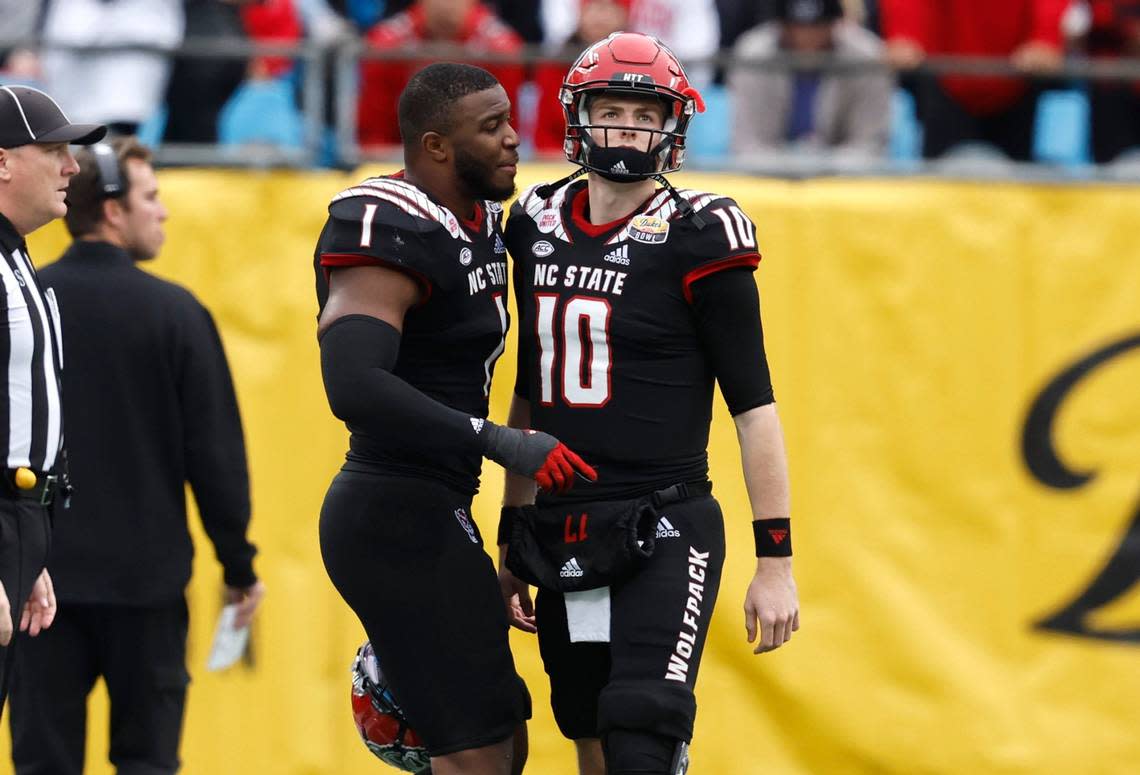N.C. State linebacker Isaiah Moore (1) encourages quarterback Ben Finley (10) after the Pack went three and out during the second half of Maryland’s 16-12 victory over N.C. State in the Duke’s Mayo Bowl at Bank of America Stadium in Charlotte, N.C., Friday, Dec. 30, 2022.